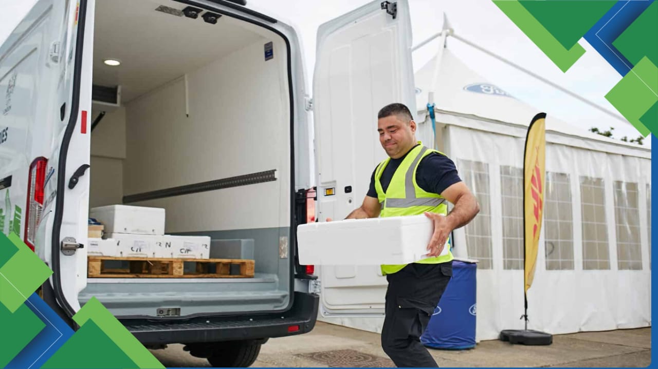 Professional driver loading refrigerated goods into a chiller van with proper PPE
